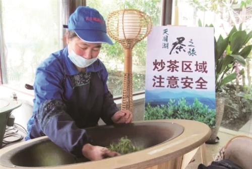 游客采摘的茶叶由炒茶女工当场炒制